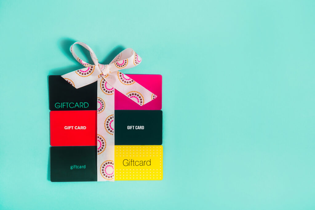 Gift cards stacked to look like a square present with a bow on top